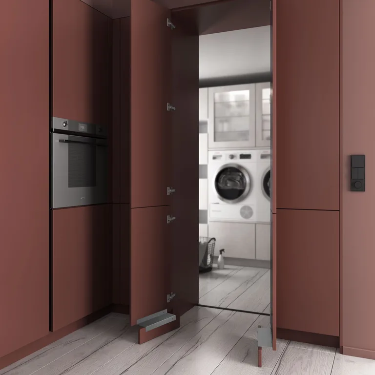 Passage dissimulé vers une buanderie aux façades terracotta coordonnées à la cuisine