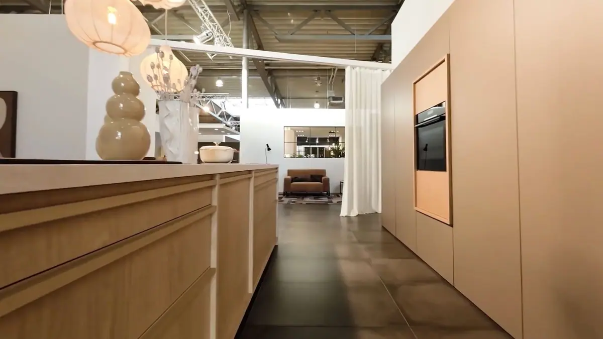 Intérieur du showroom Terra Kitchen à Anderlecht, cuisine d’exposition aux façades beiges et lumière douce
